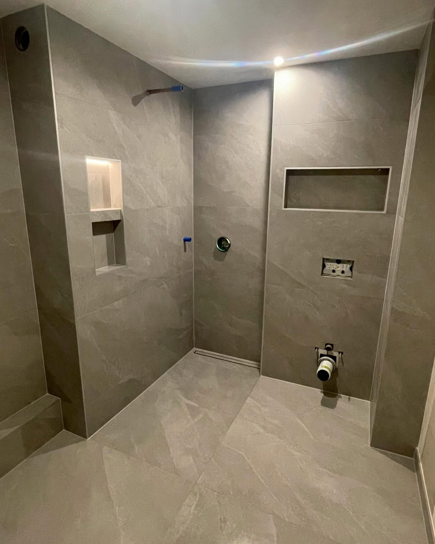 Douche avec carrelage gris et niches